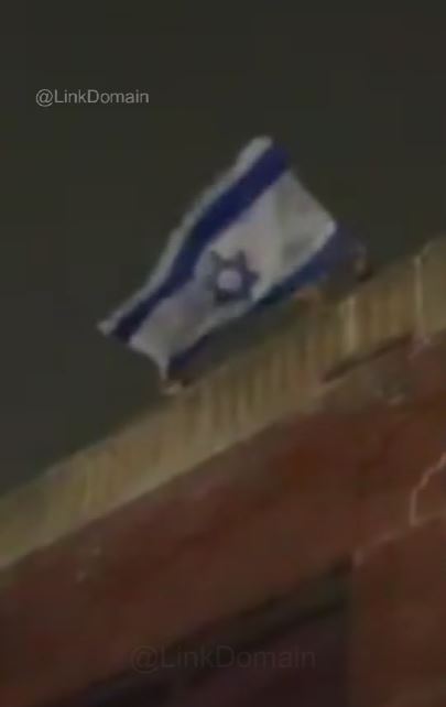 Image of Senator John Fetterman, rooftop with an Israeli flag.